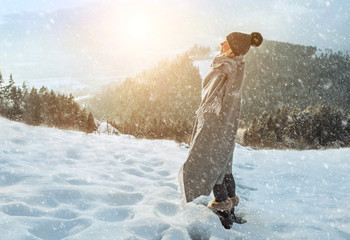 Happy woman traveler on the snowy of mountain look on the nice w