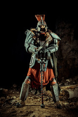 Powerful knight in the armor with the hammer. Dungeon on the background.