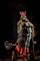 Powerful knight in the armor with the hammer. Dungeon on the background.