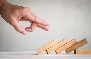 part of human finger push wooden domino on table