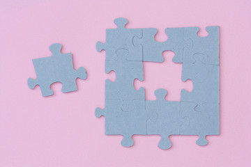 Puzzle pieces on light pink background.