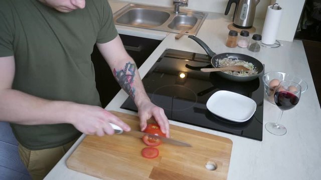 Man cutting tomato