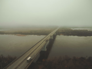 highway goes into foggy distance through autumn landscape