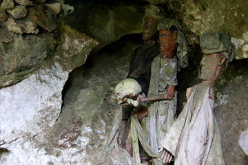Guardians of the Dead (Tau-Tau’s) holding a Human Skull in the Tampang Allo Burial Cave, Sulawesi, Indonesia