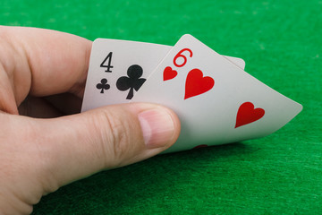 Hand with playing cards in casino