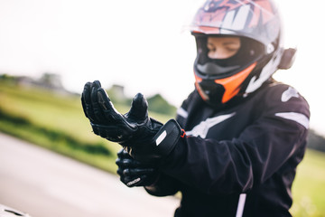 Woman preparing to drive a motorbike. Wearing gloves