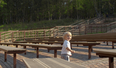 Fototapeta na wymiar Boy walking between the benches