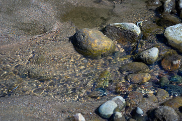 Close-up View of Colorful Pebbles, Coarse Sand in Water Waves.