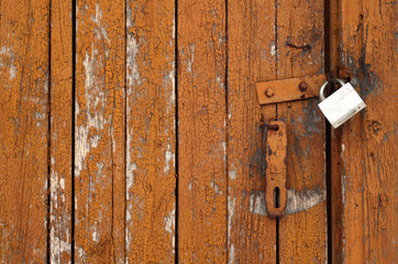 Grungy wooden door with lock.