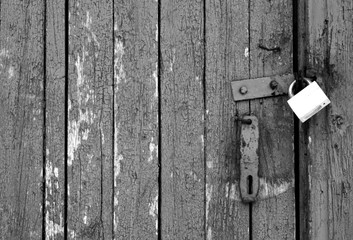 Grungy wooden door with lock in black and white.