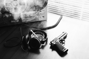 Reel tape recorder for wiretapping. KGB spying conversations. Black gun nearby. Ashtray with a...