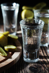 Three shots with vodka and pickled cucumbers
