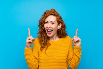 Redhead woman with yellow sweater pointing up a great idea