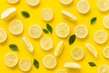 Lemon and leaves pattern on yellow background top view - obrazy, fototapety, plakaty