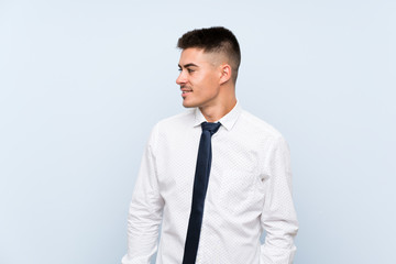 Handsome businessman over isolated blue background looking to the side