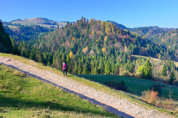 Woman backpacker on hiking trail in the mountains in autumn sunny day, Pieniny, Poland © Jurek Adamski