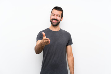 Young handsome man over isolated white background shaking hands for closing a good deal