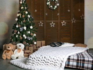 Bedroom with Christmas decoration. New Year tree, wreath, decorations. Gifts under the Christmas tree. Brown and white colors.