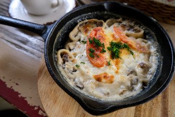 Lazy dumplings with mushrooms and cheese. Baked food in a pan.