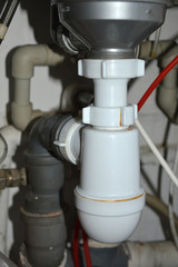 Pipes and plumbing under the sink in the kitchen