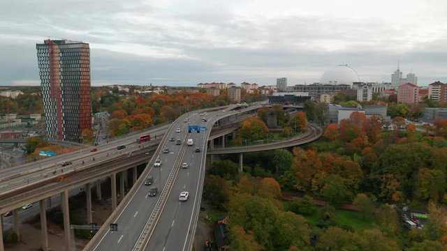 Drone flies backward over Stockholm traffic. Aerial view of Ericsson Globe, Sweden.