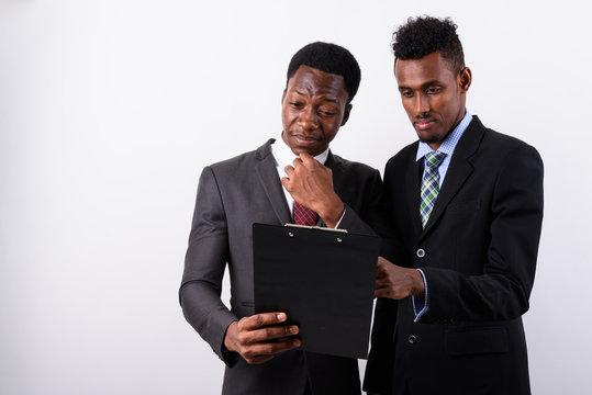 Two young African businessmen against white background
