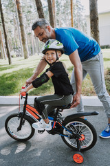 Obraz premium Father teaching his daughter to ride a bicycle
