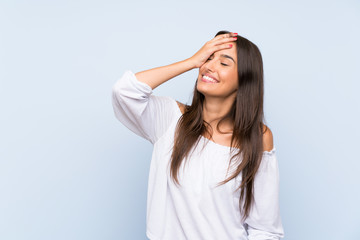 Naklejka premium Young woman over isolated blue background laughing