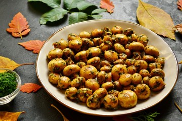 Fragrant fried champignons. Grilled mushrooms in a beautiful plate. Autumn leaves. Autumn composition with food, with mushrooms.