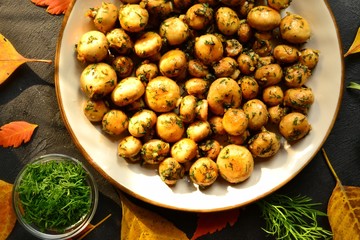 Fragrant fried champignons. Grilled mushrooms in a beautiful plate. Autumn leaves. Autumn composition with food, with mushrooms.