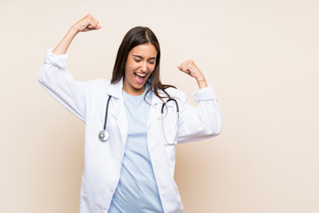 Young doctor woman over isolated background celebrating a victory