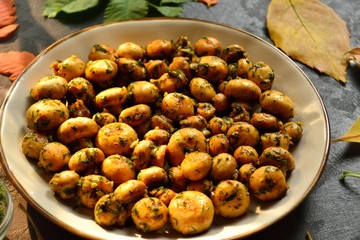 Fragrant fried champignons. Grilled mushrooms in a beautiful plate. Autumn leaves. Autumn composition with food, with mushrooms.