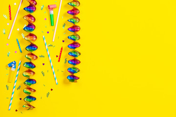 Bithday party decorations on yellow background, top view