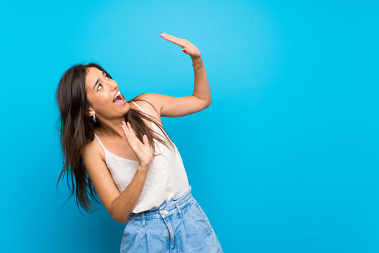 Young woman over isolated blue background nervous and scared