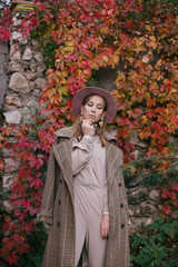 Woman in fashion clothes posing in beautiful yard.