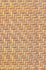 Texture of woven plant bark for furniture. Smooth wood texture of woven bamboo. Symmetric background weave of straw beige color.