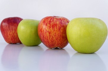 Red and green apples on white background