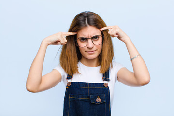 young pretty woman with a serious and concentrated look, brainstorming and thinking about a...