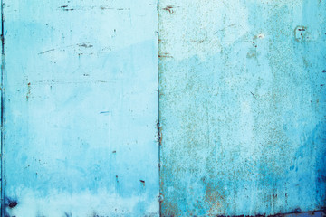 Texture of an old metal wall with rust painted blue and white paint.