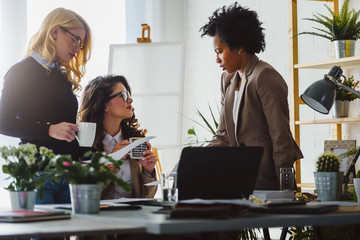 Women only business office. Woman entrepreneur. Diverse business team discussing work in their creative office.