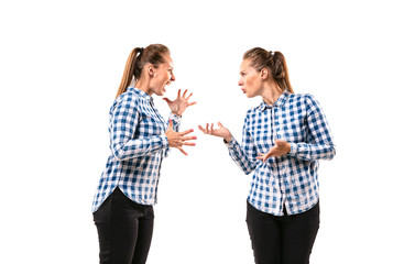 Young handsome woman arguing with herself on white studio background. Concept of human emotions, expression, mental issues, internal conflict, split personality. Half-length portrait. Negative space.