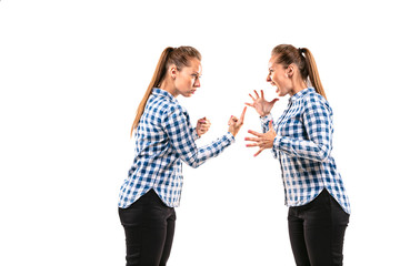 Young handsome woman arguing with herself on white studio background. Concept of human emotions, expression, mental issues, internal conflict, split personality. Half-length portrait. Negative space.