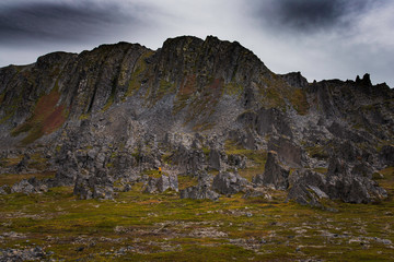 Coastal rock formation with tiny figure in yellow jacket