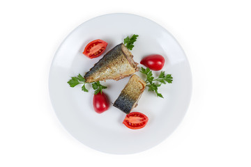 Top view of baked mackerel slices with greens and tomatoes