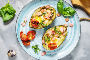 Keto diet: Avocado with ham, quail eggs, cheese on concrete background