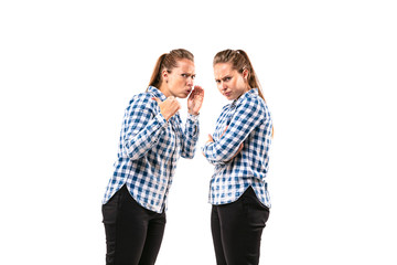 Young handsome woman arguing with herself on white studio background. Concept of human emotions,...