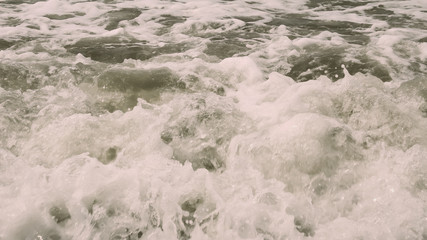 High Angle View Of Rippling Splashing Ocean Waves. Rippled sea water wave Wallpaper wet background decor for mobile and desktop screens. Vintage retro style colour effect. Copy space room for text.