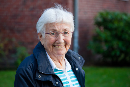 Portrait of very old happy senior woman with white hair outdoors