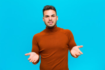 young hispanic man feeling clueless and confused, not sure which choice or option to pick,...