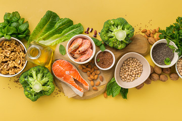 Omega 3 food sources and omega 6 on yellow background top view. Foods high in fatty acids including...